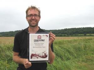 Damon holding the award